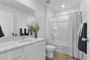 Full bathroom featuring vanity, light wood-style flooring, and shower / bathtub combination with curtain
