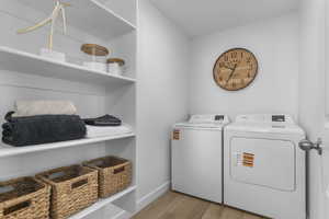 Laundry room with light wood-type flooring and separate washer and dryer