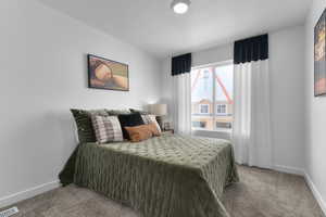Bedroom featuring carpet floors and a textured ceiling