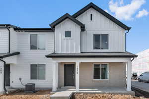 View of front of home with board and batten siding, brick siding, and a porch