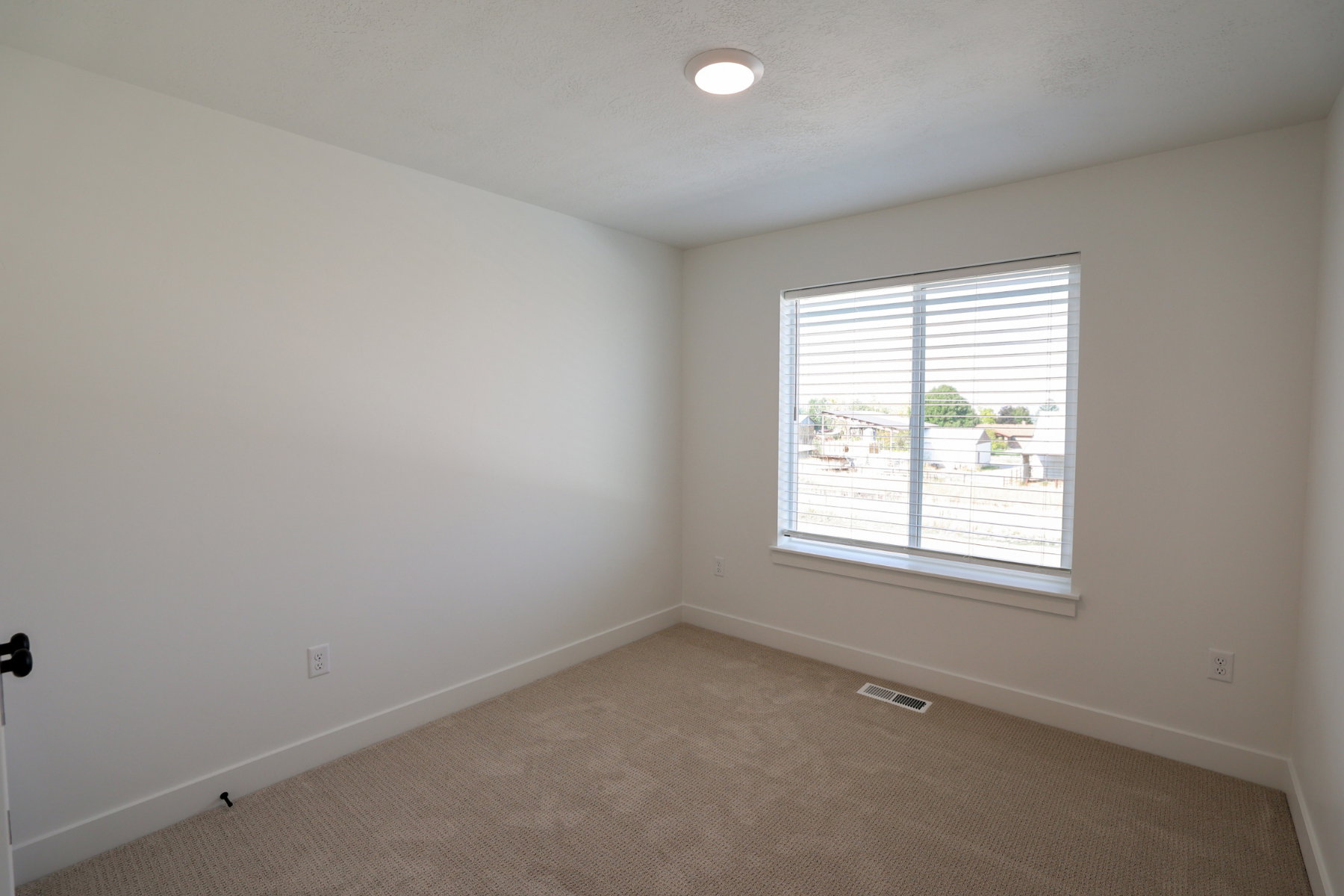 Carpeted spare room featuring baseboards