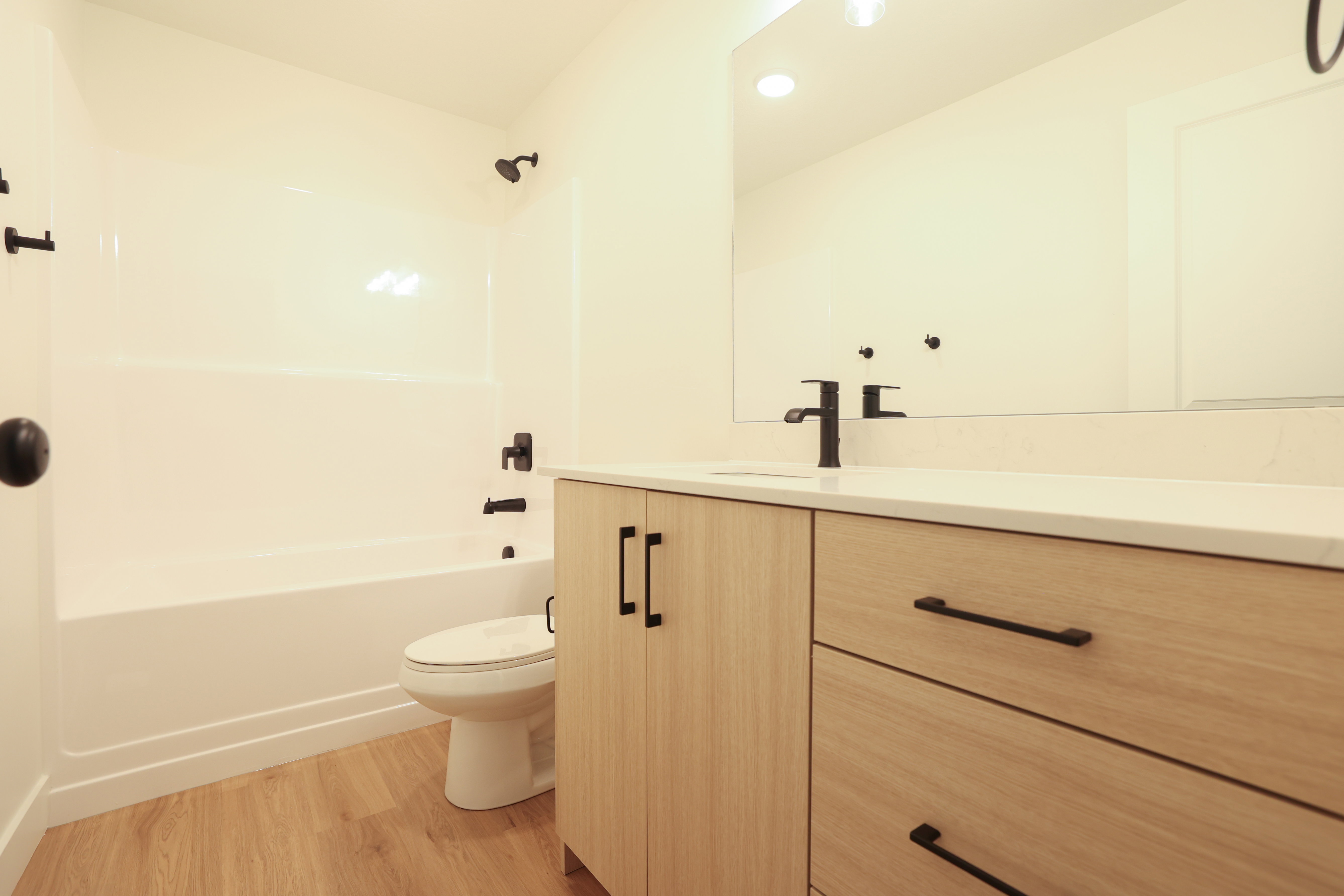 Full bath featuring vanity, light wood-style flooring, bathtub / shower combination, and recessed lighting