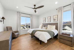 Bedroom featuring a mountain view, light wood-type flooring, a ceiling fan, and recessed lighting