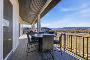 Wooden deck featuring a residential view, outdoor dining space, and a mountain view