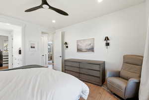 Bedroom with light wood-style floors, ceiling fan, and recessed lighting