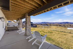 View of patio / terrace with a hot tub and a mountain view