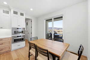 Dining room with light wood-style flooring, a mountain view, and recessed lighting
