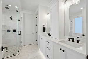 Bathroom featuring double vanity, a shower stall, recessed lighting, and light marble finish floors