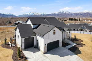 Modern farmhouse style home with roof with shingles, board and batten siding, and concrete driveway
