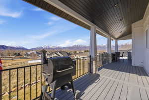 Deck with grilling area, a residential view, and a mountain view