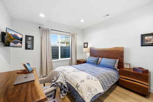 Bedroom featuring light wood-type flooring, recessed lighting, and an office area