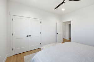 Bedroom featuring light wood-style flooring, a ceiling fan, a closet, and recessed lighting