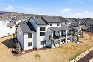 Rear view of property featuring roof with shingles, a residential view, and a patio area