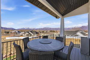 Balcony with a residential view, outdoor dining area, and a deck with mountain view