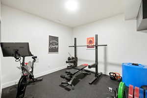 Exercise room featuring rubber floors and baseboards