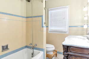 Full bathroom featuring tile wallsand shower/tub combination