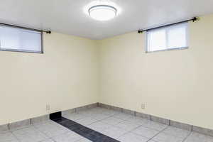 Empty room featuring light tile patterned flooring and baseboards