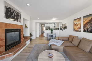 Living room with light wood-type flooring, recessed lighting, and a fireplace