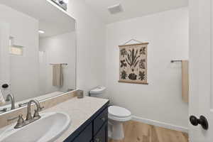 Full bath featuring vanity, curtained shower, and light wood-style flooring