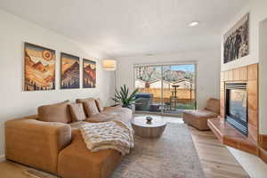 Living area featuring a tile fireplace, recessed lighting, and light wood-style flooring