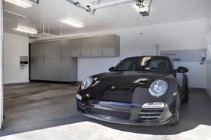 Garage featuring baseboards and a garage door opener