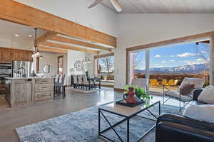 Living room featuring finished concrete floors, a mountain view, ceiling fan, a chandelier, and lofted ceiling