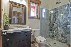 Bathroom featuring vanity and a marble finish shower