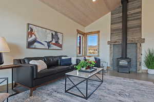 Living area with a wood stove, a vaulted wood ceiling, and recessed lighting