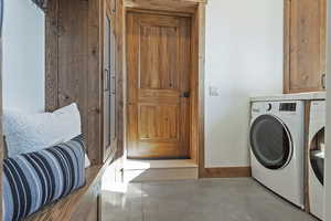 Laundry room featuring concrete flooring and cabinet space