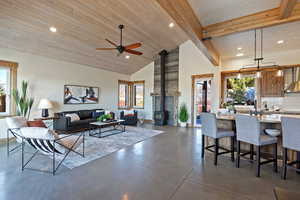 Living room with a wood stove, concrete flooring, lofted ceiling, recessed lighting, and ceiling fan