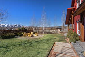 Fenced backyard featuring a patio, an outdoor fire pit, and a mountain view