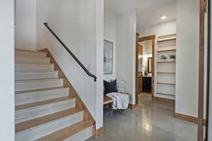 Stairs with finished concrete floors and recessed lighting