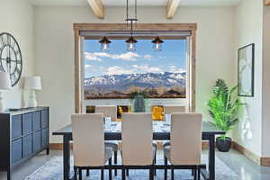 Dining space with finished concrete flooring, suspended lighting, and beam ceiling