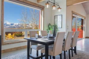 Dining space with a mountain view and vaulted ceiling with beams
