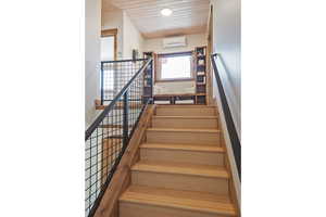 Stairway with wooden ceiling and a wall mounted mini split
