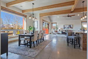 Dining area with concrete floors, beam ceiling, a ceiling fan, and hanging lights