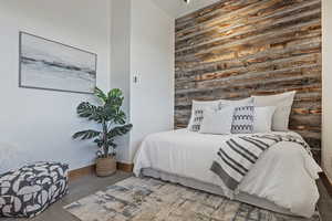 Bedroom featuring an accent wall and baseboards