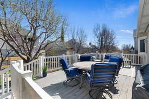 Wooden deck featuring a residential view and outdoor dining area