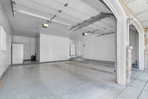 Garage with freestanding refrigerator and a garage door opener