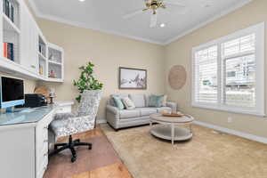 Office area with a ceiling fan, light wood finished floors, ornamental molding, recessed lighting, and built in desk