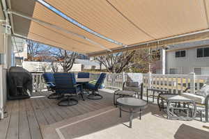 Wooden terrace featuring outdoor dining area and a grill