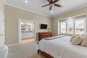 Bedroom with ornamental molding, light colored carpet, ensuite bathroom, a ceiling fan, and recessed lighting
