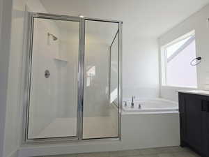 Full bathroom featuring a bath, vanity, a stall shower, and light tile patterned floors