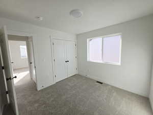 Unfurnished bedroom with dark carpet and a closet