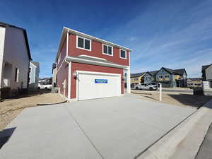 View of side of home with a residential view and concrete driveway