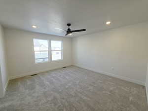 Empty room featuring light carpet, recessed lighting, a textured ceiling, and ceiling fan
