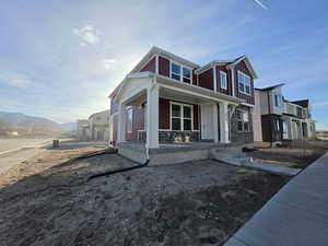 View of front of property with covered porch, stone siding, and a mountain view