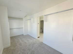 Unfurnished bedroom featuring light colored carpet and a closet