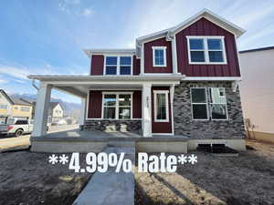 View of front of property featuring covered porch, a mountain view, and board and batten siding