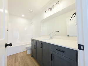 Full bath with vanity, light wood-style floors, and bathtub / shower combination